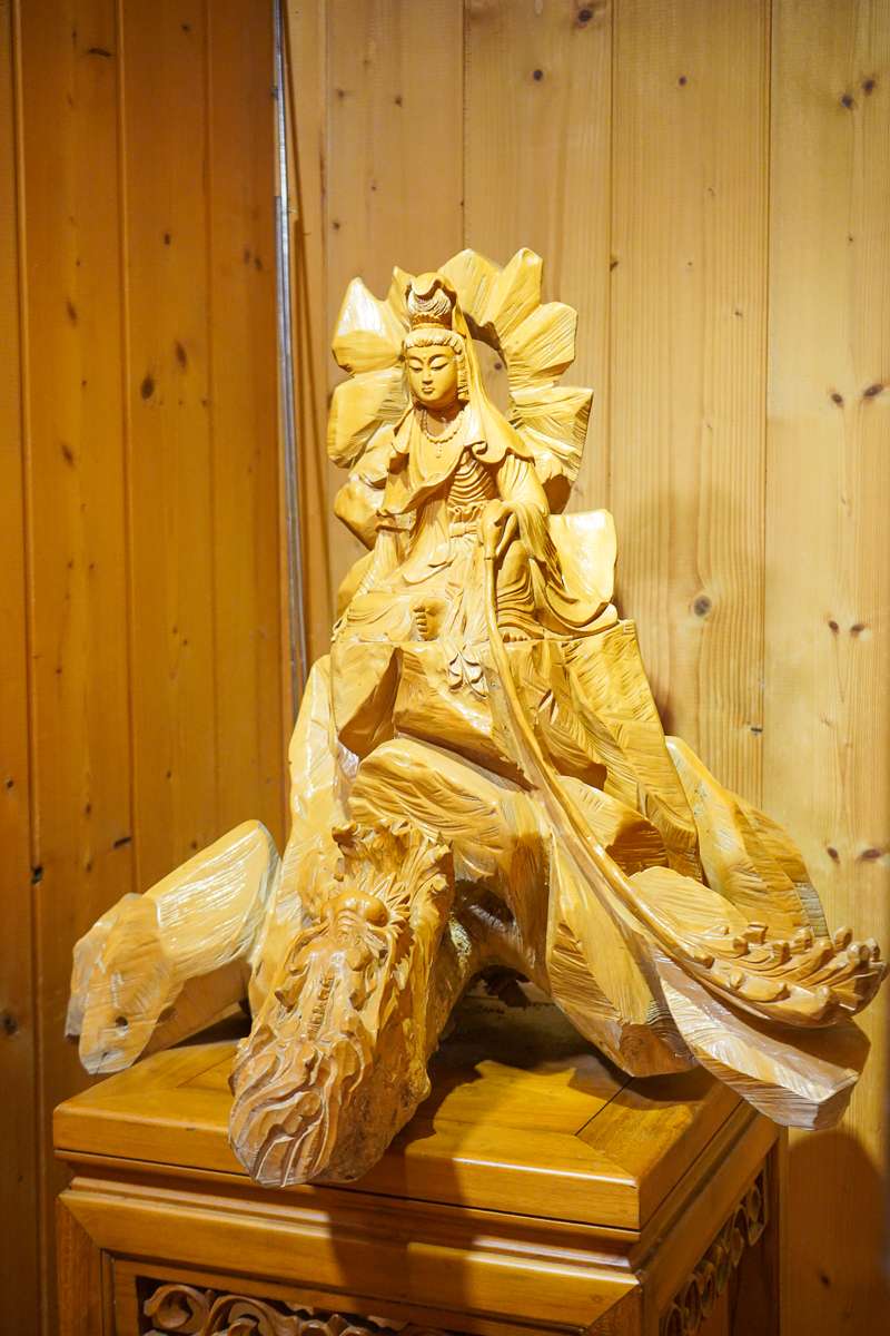就在櫃台旁邊有幾尊木雕展示著，像這尊就是觀世音菩薩的法相，木質的材料散發出不一樣的感覺