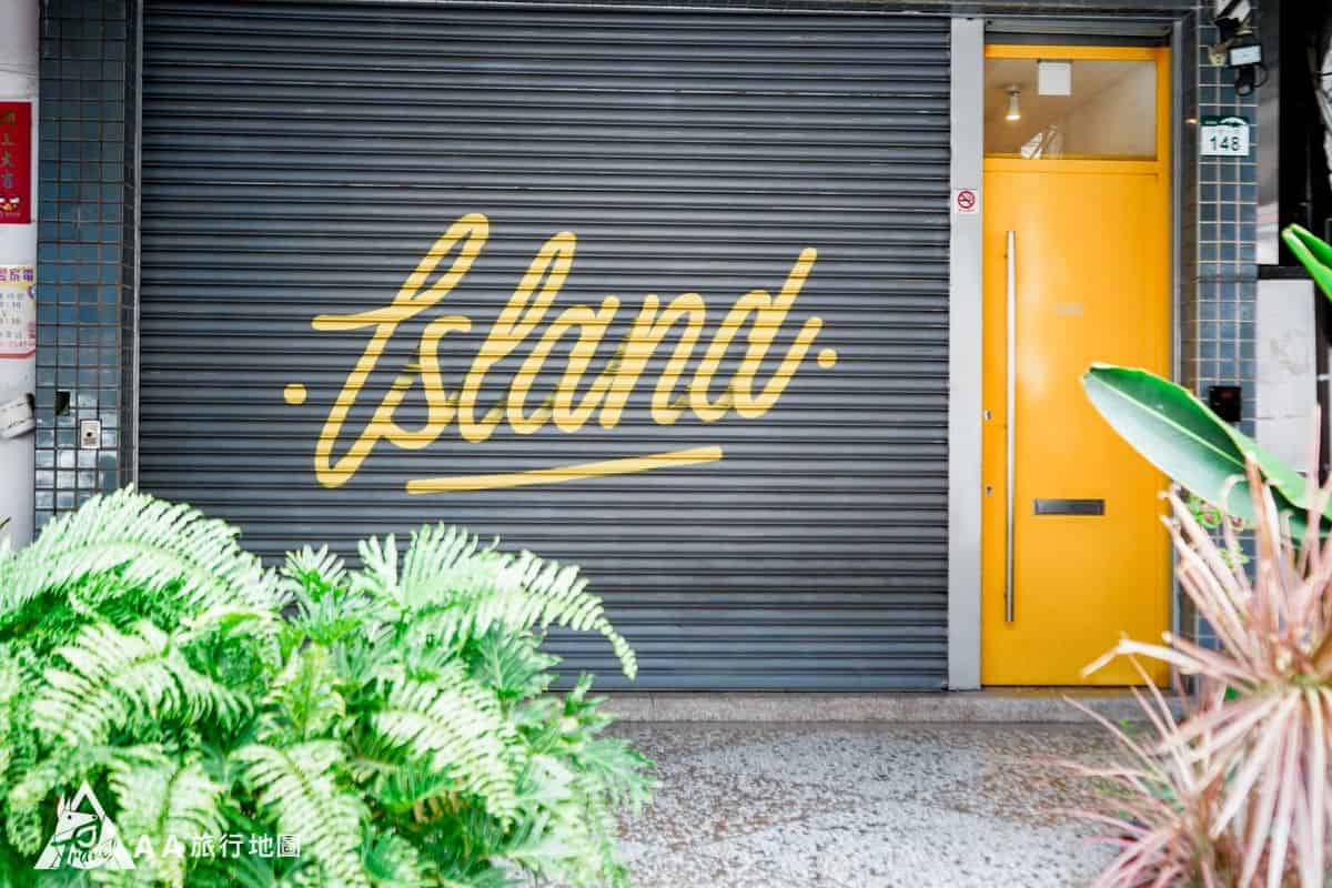 如果是白天的時候來，樓下的小島酒吧還沒有營業，就會像這樣有一個寫著黃色字的鐵門，旁邊有一道黃色的門，就是進小島公寓的門